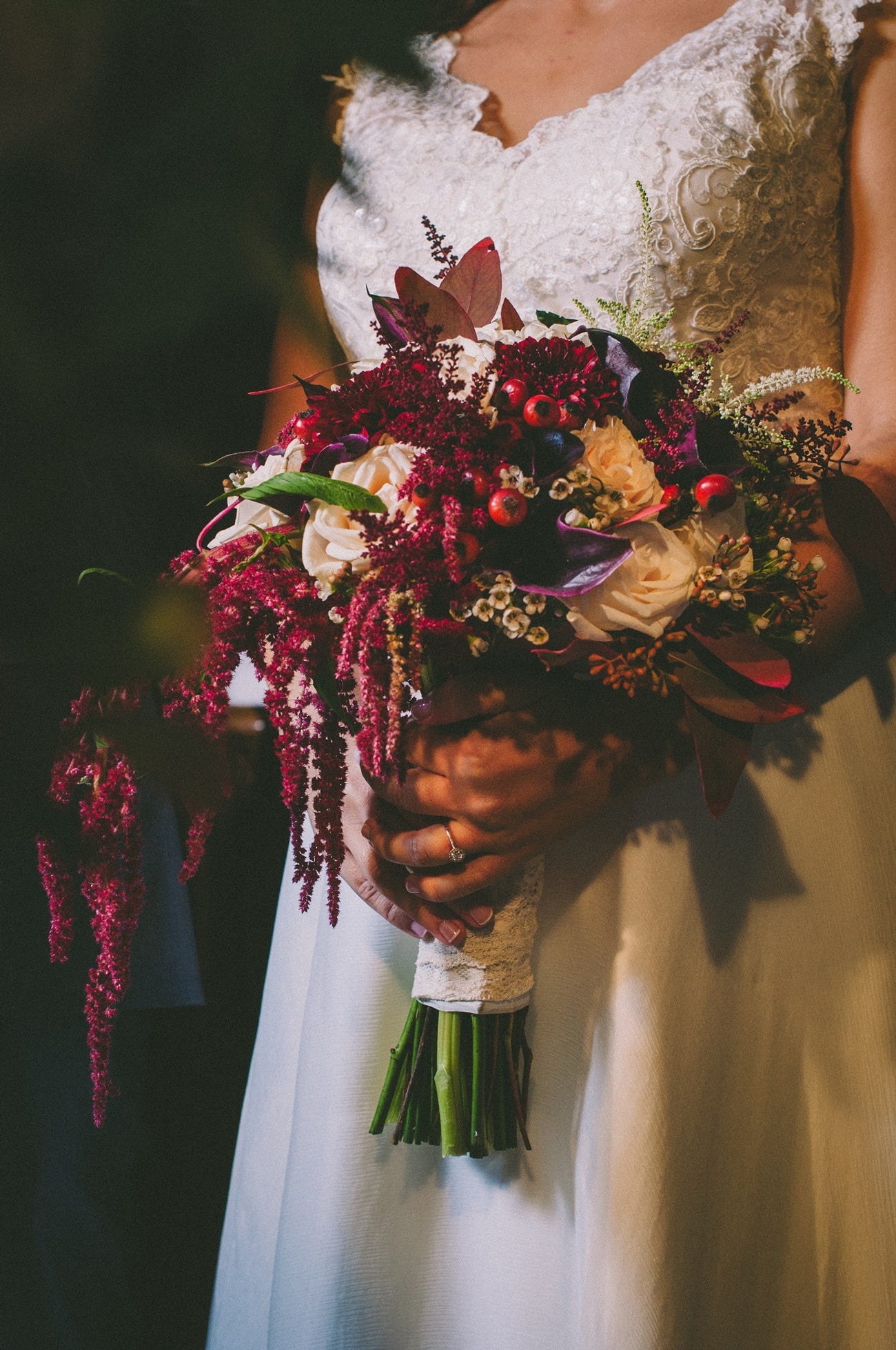Bridal bouquet in dark red colors with cala lilies, roses and berries