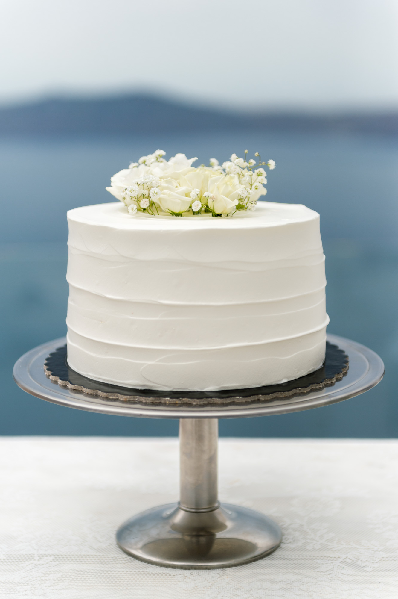 Λευκή naked τούρτα γάμου με φρέσκα λουλούδια